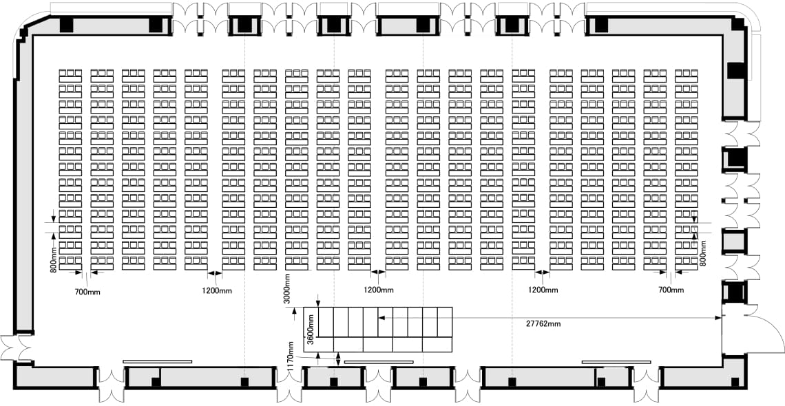 全面横使いスクール型の5階ホールレイアウト図。正面のステージに向かって、3名掛けの机と椅子が並んでいます。